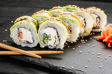 Avocado sushi rolls with cream cheese on black background