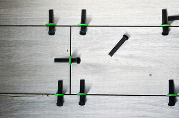 Photo of using plastic clamps and wedges to leveling the large ceramic tile on the floor.