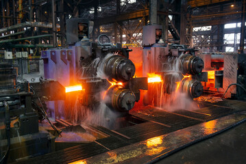 hot steel on conveyor in a steel mill - obrazy, fototapety, plakaty