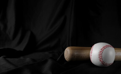 Baseball bat and ball on black drape background and texture, curtain backdrop 