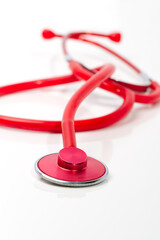 Red stethoscope on white background, close up