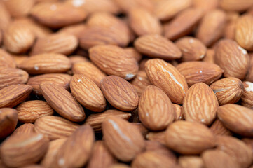 Almonds scattered on the table. Close-up, selective focus.