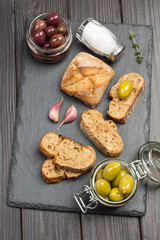 Obraz na płótnie Canvas Green olives and slices of bread. Olive oil in glass jar