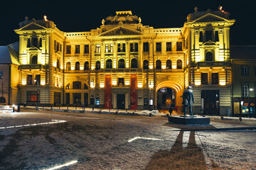 Lithuanian National Philharmonic in Vilnius, night view with snow and monument of Jonas Basanavičius