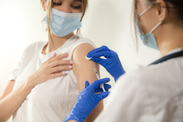 Test. Close up doctor or nurse giving vaccine to patient using the syringe injected. Works in face mask. Protection against coronavirus, COVID-19 pandemic and pneumonia. Healthcare, medicine.
