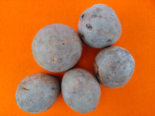 Top view of five fresh sapodilla or chikoo isolated on orange background