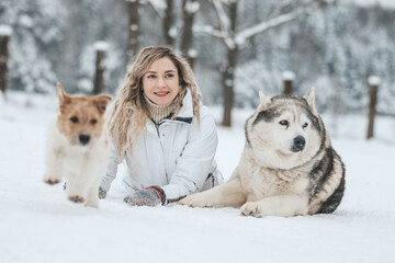 Girl playing with siberian husky in winter forest and park