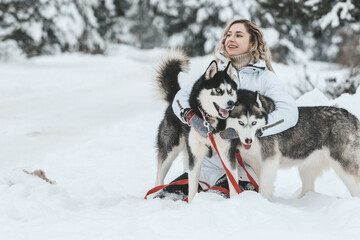 Girl playing with siberian husky in winter forest and park