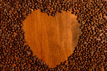 Heart made of coffee beans on a wooden table