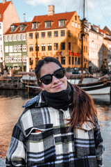 Fototapeta na wymiar woman with sunglasses wearing warm clothes in a city on a sunny day