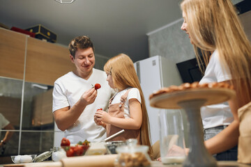 Mother and daughter are preparing pancakes. Family cooking. Preparing breakfast. Knead the dough. Soiled in flour, hug each other