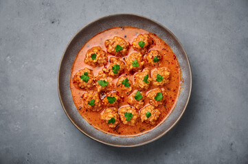 Sulu Kofte in gray bowl on concrete table top. Turkish cuisine soup dish with beef meatballs and gravy. Traditional food. Top view