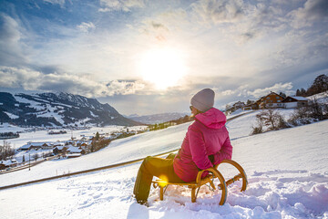 Germany, Bavaria, Allgäu, Woman enjoying a winter day sledding