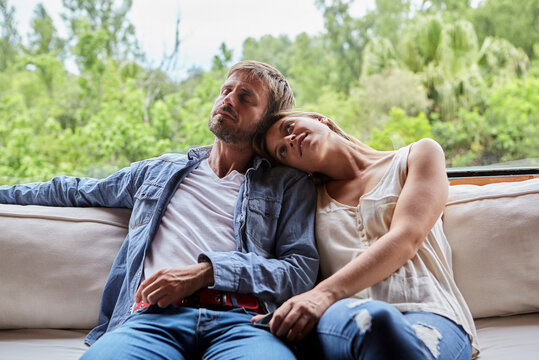 Thoughtful couple sitting on sofa