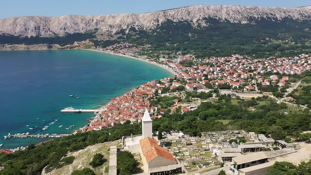Aerial footage of the Ba&scaron;ka resort town and beach in the Krk island in Croatia on a sunny summer day in the Balkans.