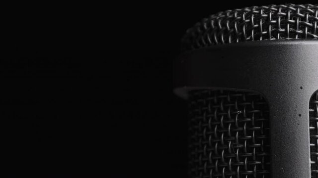 Studio Condenser Microphone Rotates on Black Background with Place for Text