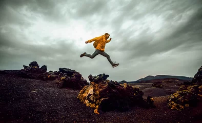 Deurstickers Wandelaar man springen over de berg. Vrijheid, risico, succes en uitdaging. Focus op de mens © Davide Angelini