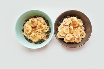 Healthy breakfast. Top view. Oatmeal with banana and flax seeds at bowl. Berry in plate. Organic meal recipe. Vegan cook. Minimalism granola. Hot porrigde with fruit