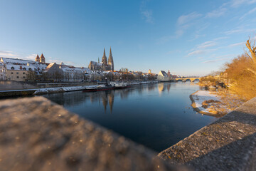 The famous skyline of the bavarian town Regensburg with the danube river on sunny winter morning with snow and ice