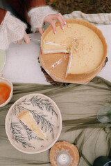 Hands cut a wedding cake in autumn in Altai