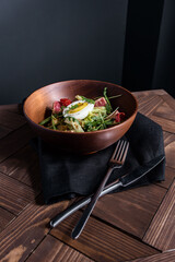 Wooden plate with food served on the table on black background
