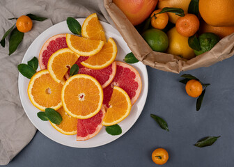 Close up image with sliced citrus fruits composition on a grey background. top view