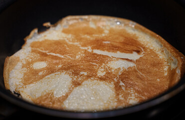 Pancake on frying pan. Making of pancakes.
