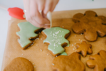 Decorating Christmas gingerbread cookies in the kitchen