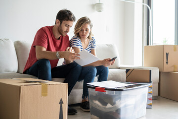 Young couple reading documents in their new house