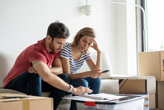Young couple reading documents in their new house