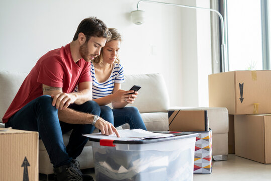 Young couple reading documents in their new house