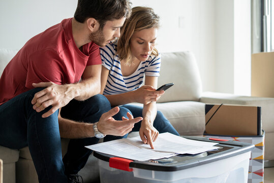 Young couple reading documents in their new house