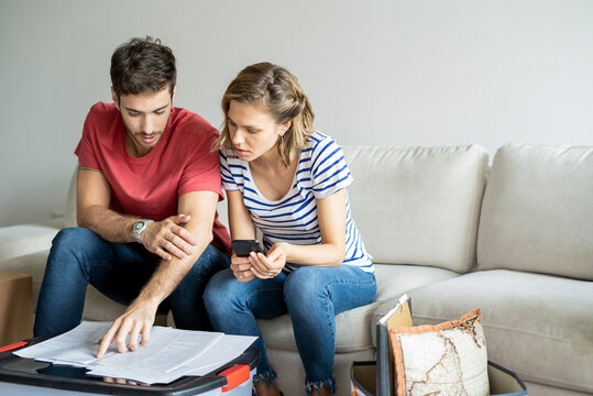 Young couple reading documents in their new house