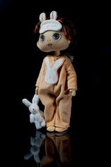 Doll in beige overalls with a hare. 