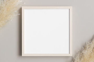 Top view of a wooden square frame mockup with pampas decoration.