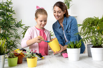 Mom and her daughter preparing all the necessities for replanting, from soil to flower pots