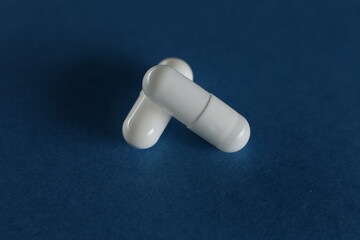 Two medical pills on a blue background