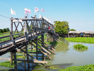 The good view of 100 Years wooden Bridge of Riverside community and floating market,Tha Chin River, Thailand