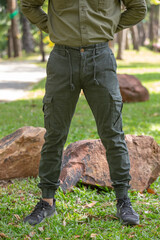 young man in green pant standing  in the park