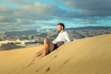 Fototapeta na wymiar Man in the dunes in Maspalomas in Gran Canaria during sunset