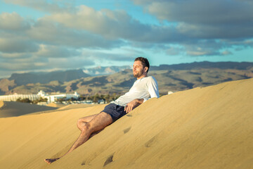 Fototapeta na wymiar Man in the dunes in Maspalomas in Gran Canaria during sunset