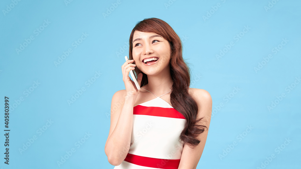 Wall mural beauty woman talk on phone isolated on blue background