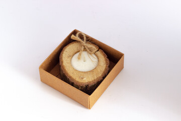 Candle isolated on a white background.
Log wooden candle, white background with gift package. The best view. Selective focus.