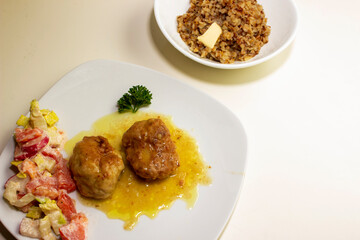 pork cutlets with buckwheat porridge garnish on a white background