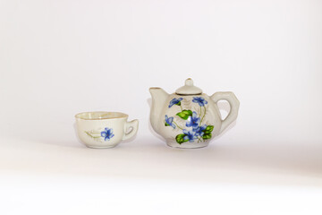 Ceramic mini tea set isolated on white background. Miniature blue and white ceramic tea set.