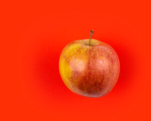 Fresh red apple on red background.