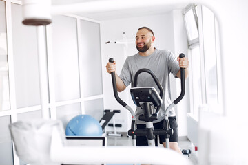 A man is doing the exercises. He has a training. The patient uses a spin bike.