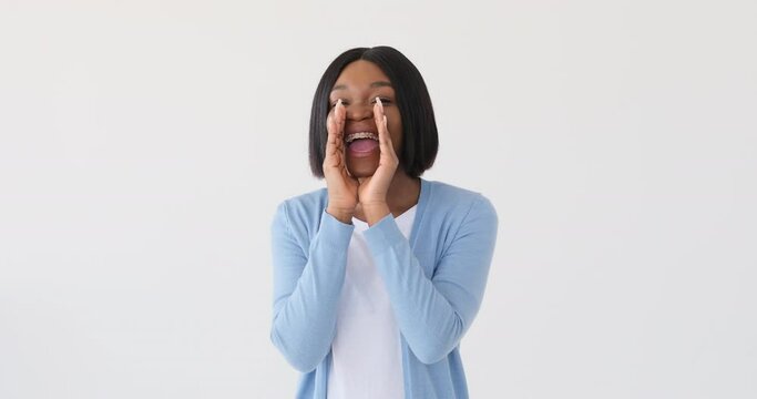 African American woman shouting with hands cupped around mouth