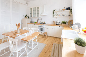 cute cozy light interior design of the apartment with a free layout of the kitchen and bedroom areas. a lot of windows, a wooden floor and a hanging swing.