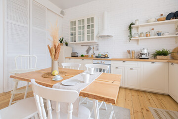 cute cozy light interior design of the apartment with a free layout of the kitchen and bedroom areas. a lot of windows, a wooden floor and a hanging swing.